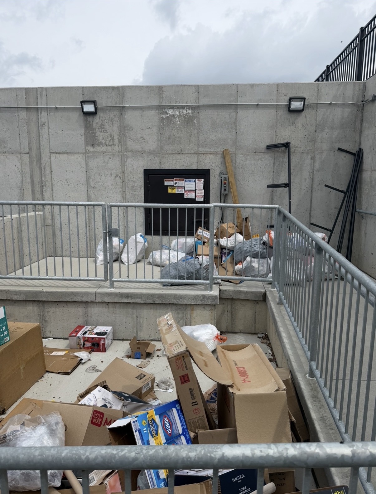 Commercial loading dock covered in broken-down cardboard and bagged trash