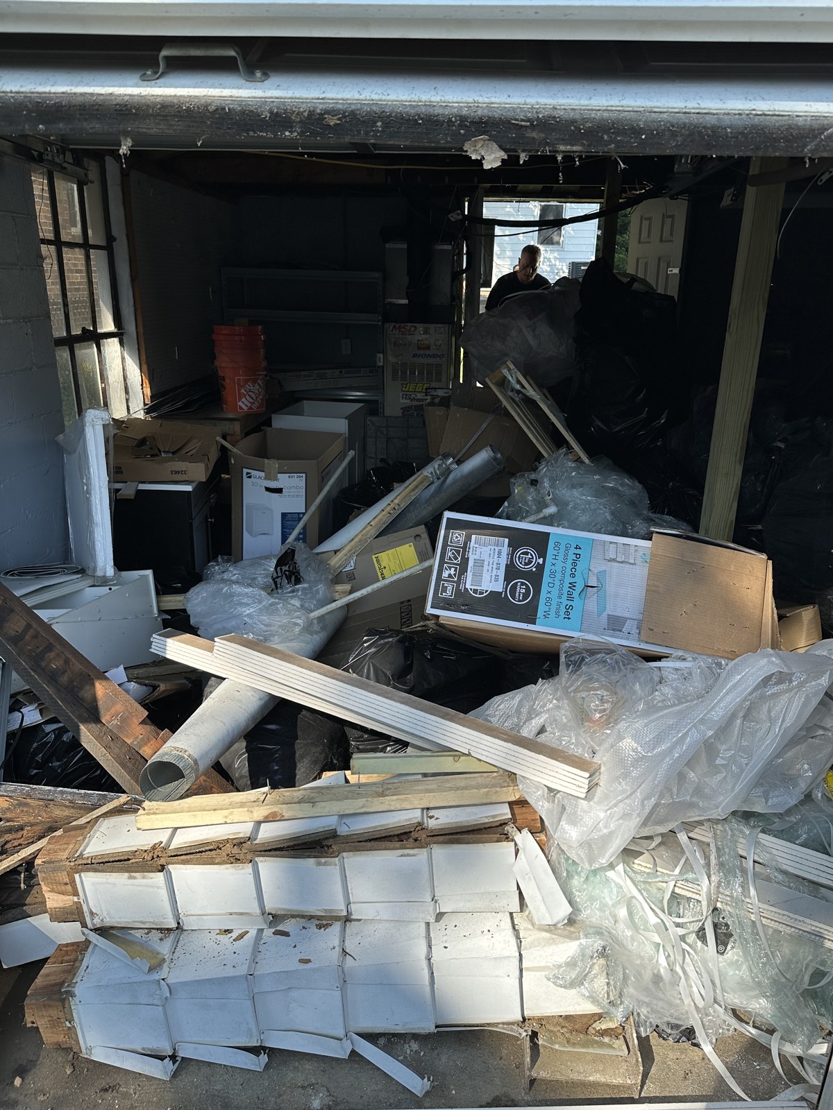 Loaded garage bay full of siding, lumber and packaging ready to be cleared out