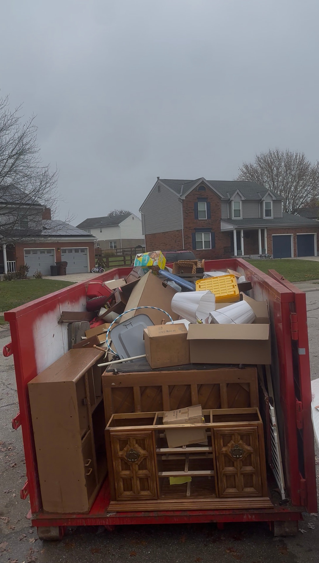Loaded junk removal dumpster in front of a Northern Kentucky home